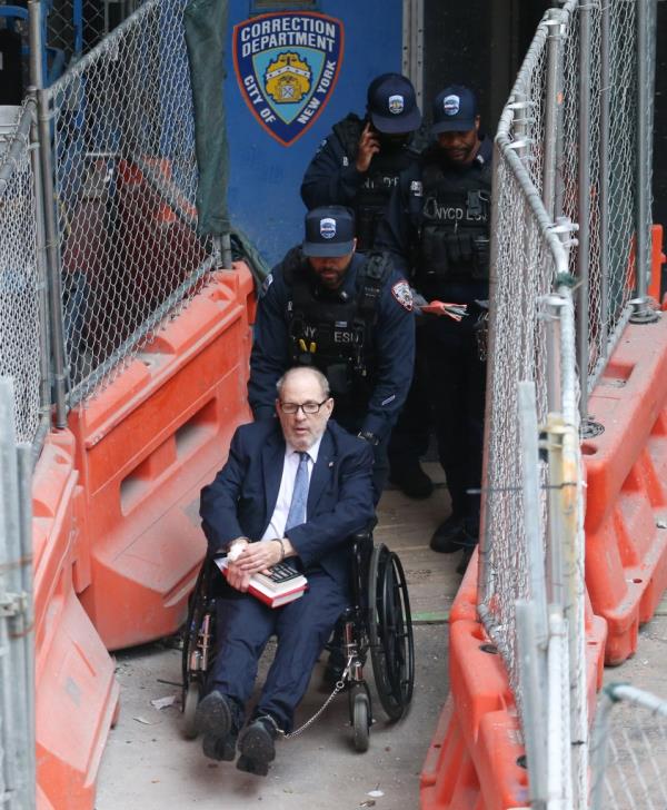 Harvey Weinstein in a wheelchair exiting Bellevue Hospital, accompanied by armed NYCD ESU officers